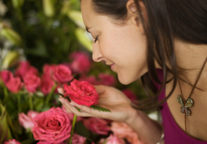 Vrouw ruikt aan geur van rozen