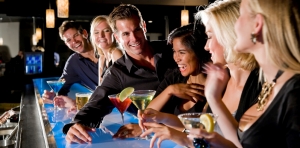 Mensen praten en lachen aan de bar onder het genot van drankjes en de juiste muziek
